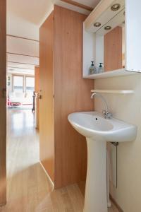een badkamer met een wastafel en een spiegel bij Heidehut in Midsland