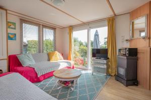 a living room with a couch and a tv at Heidehut in Midsland