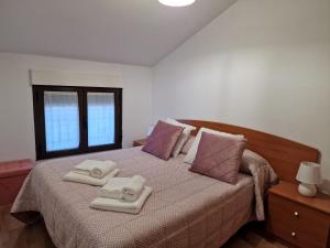 ein Schlafzimmer mit einem Bett mit zwei Handtüchern darauf in der Unterkunft Vivienda Turistica IBAMA1 in Ciudad-Rodrigo