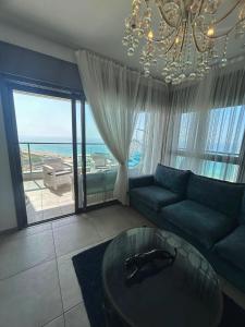 un soggiorno con divano e tavolo in vetro di Panorama Apartment " City Garden " a Bat Yam