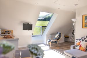 een woonkamer met een trap met een raam bij The Roost - a bird's eye view in the countryside in Cullompton