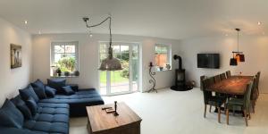 ein Wohnzimmer mit einem blauen Sofa und einem Tisch in der Unterkunft Haus Pünktchen in Tinnum
