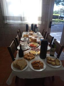 una mesa larga con platos de comida. en Pousada paraíso en Bento Gonçalves