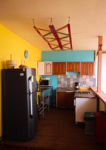a kitchen with a black refrigerator in a room at Hostal Don Jose in Santa Rosa de Cabal