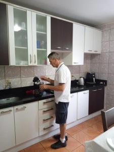 a man standing in a kitchen with a blender at Pousada paraíso in Bento Gonçalves