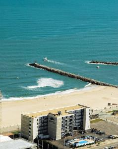 a view of a beach with a building and the ocean at The Schooner Inn in Virginia Beach