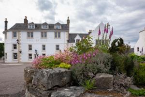 a large white building with flowers in front of it at The Bridge Helmsdale in Helmsdale