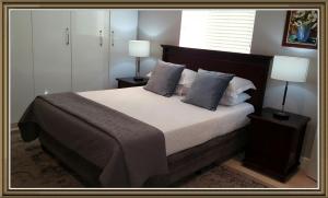 a bedroom with a large bed with two lamps at 5 Pierre Jourdan in Franschhoek
