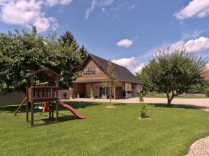 a playground in a yard with a house at Gîte L'Ecrin du Ried "COSY" in Artolsheim
