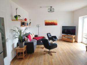 a living room with a couch and a tv at Ferienwohnung Zur Flatter-Ulme in Weißwasser