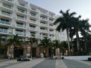 un grand bâtiment avec des palmiers devant lui dans l'établissement Suites Town Center Playa blanca, à Playa Blanca