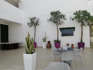 Cette chambre comprend une table, des chaises et des palmiers. dans l'établissement Suites Town Center Playa blanca, à Playa Blanca