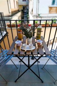 un tavolo su un balcone con tazze e piante di SANT'ANTIDA HOME a Caserta