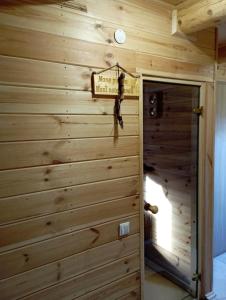 una habitación con una pared de madera con un cartel. en Meijas Nams, en Kalupe
