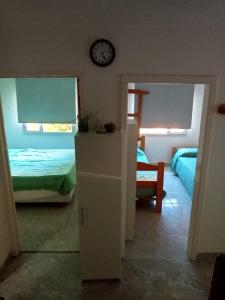 a bedroom with two beds and a clock on the wall at NUESTRO MUNDO TRELEW in Trelew