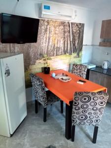 a kitchen with a red table and chairs and a refrigerator at NUESTRO MUNDO TRELEW in Trelew +7 photos