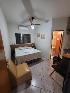 a bedroom with a bed and a ceiling fan at Hotel Graunas in São Carlos