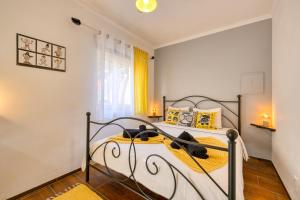 a bedroom with a metal bed with yellow pillows at Pillows Peniche B&B in Peniche