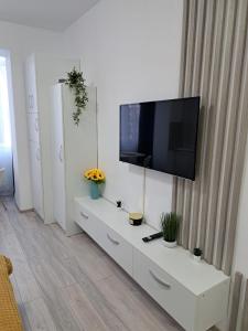 uma sala de estar com televisão num armário branco em Chic Studio em Onesti