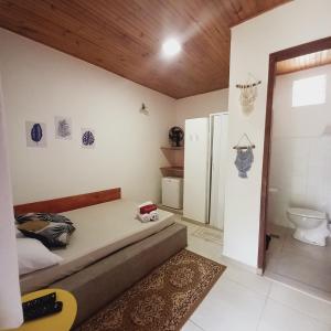 a bedroom with a bed and a bathroom with a toilet at Pousada Estalagem Moeda Real in Moeda