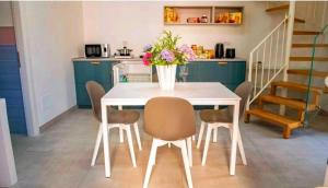 a white dining room table with chairs and a vase of flowers at SANT'ANTIDA APARTMENT in Caserta