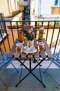 a table on a balcony with cups and plants on it at SANT'ANTIDA APARTMENT in Caserta