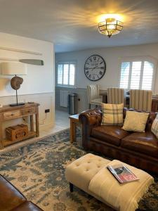 a living room with a couch and a clock on the wall at Once upon a tide in Kent