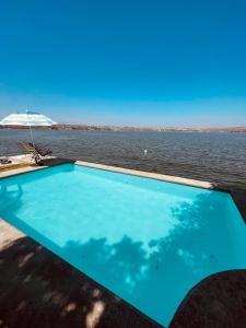 ein Schwimmbad in der Mitte eines Wasserkörpers in der Unterkunft Casa Alfenapa completa para ti y tu familia, pet friendly y a pie del lago in Tequesquitengo