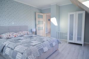Schlafzimmer mit einem Bett mit einer blauen und weißen Bettdecke in der Unterkunft Apartament u Sikorki in Ustrzyki Dolne