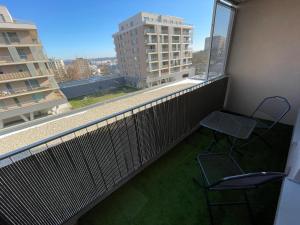d'un balcon avec une chaise et une fenêtre offrant une vue. dans l'établissement Modern and quiet apartment with air conditioning and free parking, à Košice
