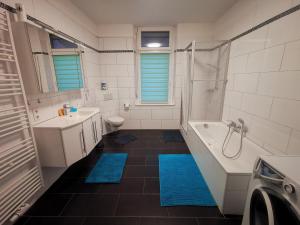 ein Bad mit einer Badewanne, einem Waschbecken und einer Dusche in der Unterkunft Quartier Langenstrich in Neunkirchen