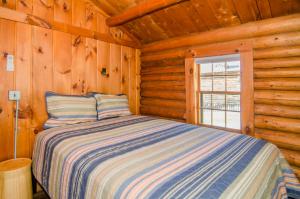 a bedroom with a bed in a log cabin at Mountain Lake Cottages in Westmore