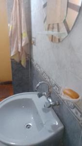 y baño con lavabo blanco y espejo. en Hag Doly Nubian geust House, en Asuán