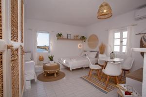 een woonkamer met een bed en een tafel en stoelen bij Hidden Serenity in Mykonos-stad