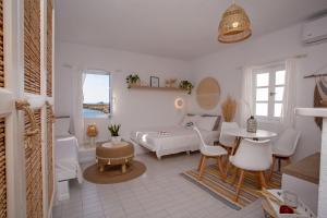 a living room with a bed and a table and chairs at Hidden Serenity in Mikonos