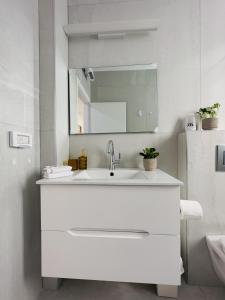 a white bathroom with a sink and a mirror at Amazing 2Rooms Apt in Bat Yam - Step by the beach in Bat Yam