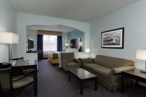 Habitación de hotel con sofá y cama en Holiday Inn Express & Suites Plant City, an IHG Hotel, en Plant City