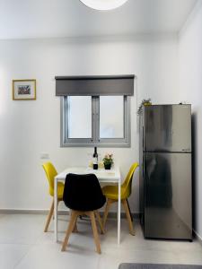 a kitchen with a white table and a refrigerator at Amazing 2Rooms Apt in Bat Yam - Step by the beach in Bat Yam