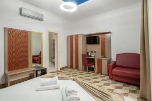 um quarto de hotel com uma cama e uma cadeira vermelha em The Five Oscars Inn em Roma