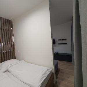 Un dormitorio pequeño con una cama blanca y una habitación con en Apartament Holiday B 210, en Pobierowo