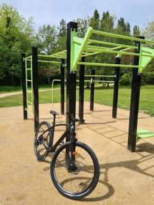 Hay una bicicleta estacionada junto a un parque infantil. en maison nature spéciale JO 2024, en Savignies