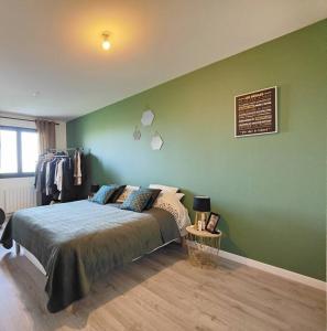 a bedroom with a bed and a green wall at maison nature spéciale JO 2024 in Savignies