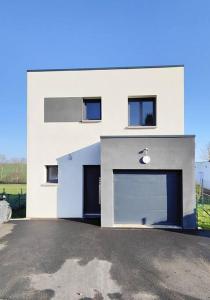 un gran edificio blanco con un gran garaje en maison nature spéciale JO 2024, en Savignies