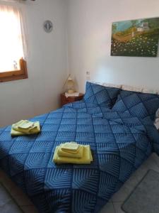 a blue bed with yellow towels on top of it at Persefoni's Traditional House in Promírion