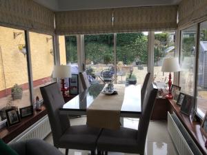 a dining room with a table and chairs and windows at Krakow B&B in Dundalk