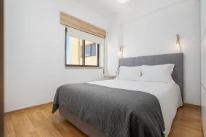 a bedroom with a large white bed with a window at Vista Rio - apartamento in Portimão