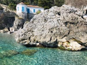 a building on top of a large rock in the water at Amalfi Sea View in Scala