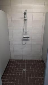 a shower in a bathroom with a tile floor at Sodyba Prie Malūno in Žagarė