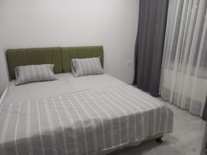 a bed with two pillows on it in a room at *Новая квартира 1+1 Mecidiyeköy in Istanbul
