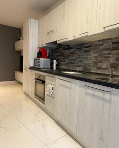 a kitchen with wooden cabinets and a microwave at Stylish 1 bedroom apartment in central Msida C11A in Msida